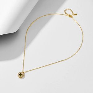 Detailed close-up of a square emerald green zircon pendant on a gold sterling silver chain