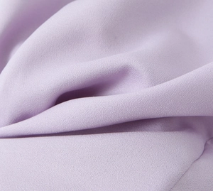 Gros plan sur la texture douce et les plis détaillés du vêtement en tissu violet