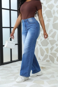 Vue latérale d'un jean bleu taille haute à jambes larges sur un mannequin en mouvement