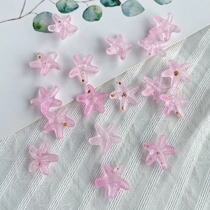 Macro view of gradient pink acrylic starfish beads with golden glitter for DIY jewelry