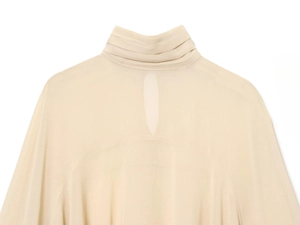 Détail du col montant et de la découpe goutte au dos d'une blouse en crêpe beige