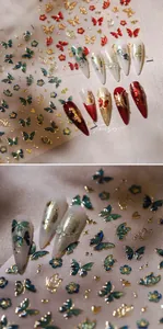 Détail macro de stickers 3D pour ongles avec papillons et fleurs rouges et dorés
