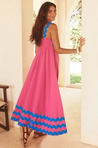 Detail view of the pink maxi dress featuring blue ric-rac trim and cotton texture