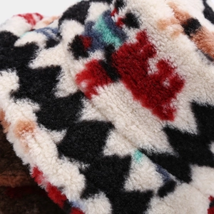 Close-up of thick plush faux fur fabric with heart patterns on a warm winter bucket hat