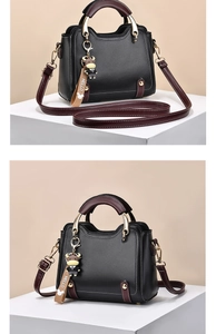 Detail of bicolored faux leather handbag with contrast stitching and gold-tone hardware detail