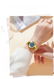 Close-up of gold luxury ladies watch featuring a blue dial and calendar display window