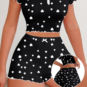 Detail view of heart pattern pajamas with ruffle trim and bow tie on the waistband