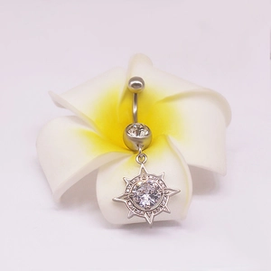 Piercing de nombril en acier inoxydable avec pendentif soleil posé sur une fleur