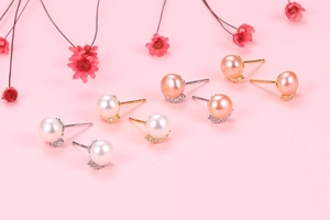 Detailed macro view of S925 silver pearl earrings with colorful rhinestones on pink decor
