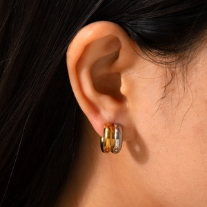 Two-tone 18K gold and silver chunky hoop earrings worn for a minimalist fashion look