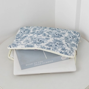 Detailed view of white and blue floral laptop sleeve with smooth zipper and fabric texture
