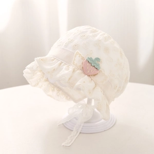 Détail du bonnet en dentelle blanche pour bébé avec fraise rose et bords festonnés
