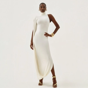 Detail of white one-shoulder maxi dress featuring an elegant cape sleeve and high neckline