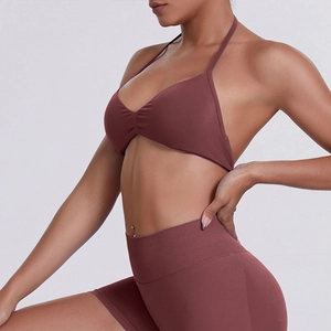 Detail of ribbed halter sports bra and high-waist shorts in seamless brick red fabric
