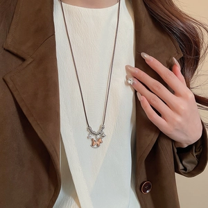 Close-up of retro wooden horse pendant necklace with silver star charms on long cord