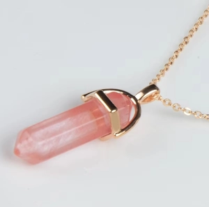 Macro shot of pink hexagonal crystal pendant with fine gold-plated chain details