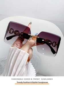 Detail of luxury gold metal temple with hollow 'D' shape and Greek key pattern on sunglasses