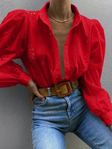Close-up of red eyelet embroidery shirt with puff sleeves and a deep V-neckline