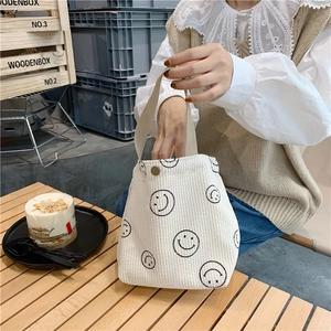 Detailed close-up of corduroy tote bag featuring black smiley prints and soft ribbed texture