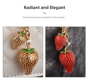 Close-up of strawberry keychain pendants with red enamel finish and golden metal details