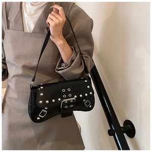 Detail of black punk motorcycle bag with silver rivets and adjustable belt straps