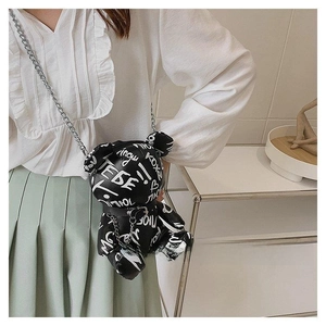 Graffiti bear shaped crossbody bag with silver metal chain on a model in casual outfit