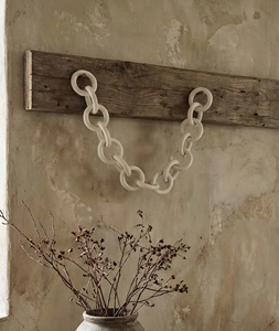 Close-up of matte ceramic chain rings showing a textured minimalist wabi-sabi wall decor