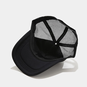 Close-up of black mesh trucker hat showing breathable texture and structured six-panel design