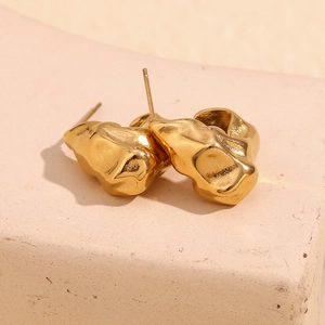Detailed view of irregular 18K gold plated stainless steel stud earrings with hammered texture