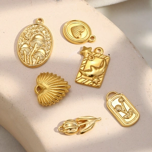 Detailansicht verschiedener 18K vergoldeter Anhänger mit Naturmotiven wie Pilzen und Muscheln
