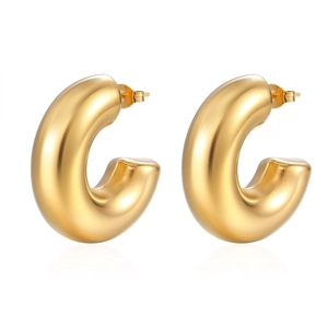 Close-up of thick gold-plated hollow C-shaped hoop earrings with a polished metal finish