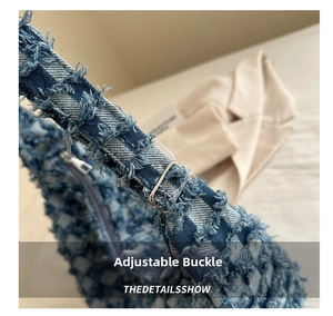 Macro detail of adjustable silver buckle on a blue shaggy denim tote bag with fringe