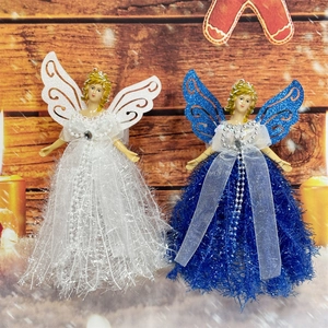Detail of white and blue Christmas angel dolls with sequins on a festive wood background
