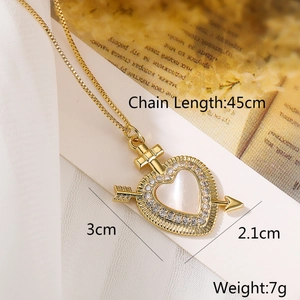 Macro shot of 18K gold plated heart pendant with shell inlay and CZ arrow detail