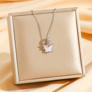Collier pendentif papillon argenté avec dégradé rose sur fond de soie élégant