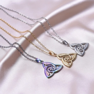 Three Celtic witch knot necklaces in gold, silver and rainbow on soft silk fabric