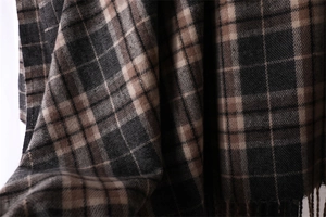 Close-up of brown, black and beige plaid scarf showing soft cashmere-like fabric texture