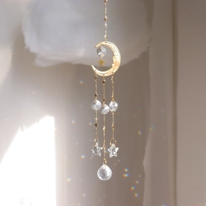 Détail du carillon lune dorée avec prismes en cristal clair et pendentifs en étoile