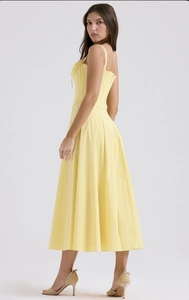 Vue latérale du haut corset jaune et de la jupe fendue mi-longue sur fond blanc de studio