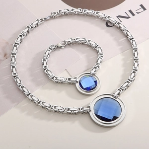 Detailed macro view of silver chunky chain necklace set with round blue faceted gemstone