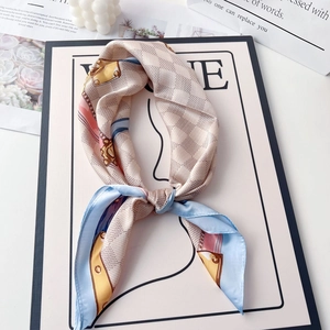 Detail of silk-like satin square scarf featuring chain prints and checkered patterns