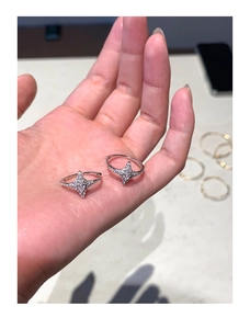 Close-up of silver star earrings with zircons held in hand showing fine craftsmanship