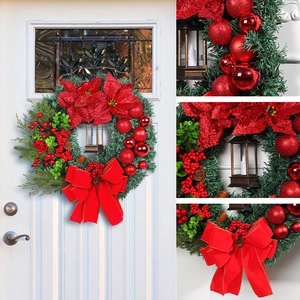 Christmas wreath with LED lantern red poinsettias and ornaments on white front door