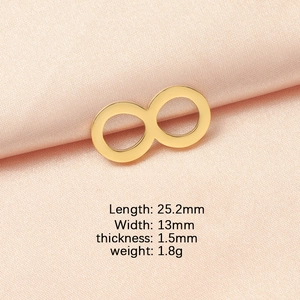 Detailed view of golden infinity symbol pendant with size measurements on pink silk fabric