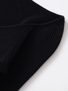 Close-up of high-quality black ribbed knit fabric showing detailed texture and stitching