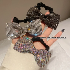 Detail of rhinestone bow hair tie set in black, silver and iridescent crystals