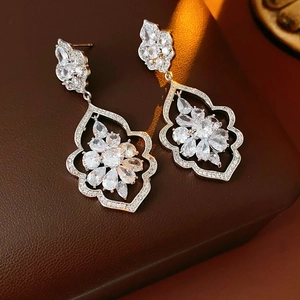 Gros plan de boucles d'oreilles fleurs en zircon avec pierres sur cuir marron