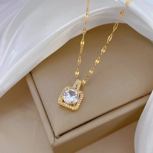 Macro detail of gold square pendant featuring a large crystal center and pavé border
