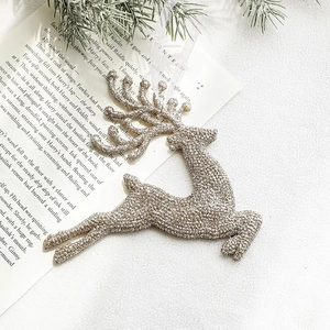 Elegant silver glitter reindeer ornament on vintage book page with pine needles