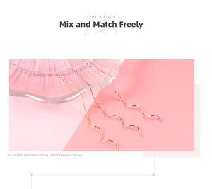 Detail of elegant wave-shaped drop earrings in gold, silver and rose gold finishes